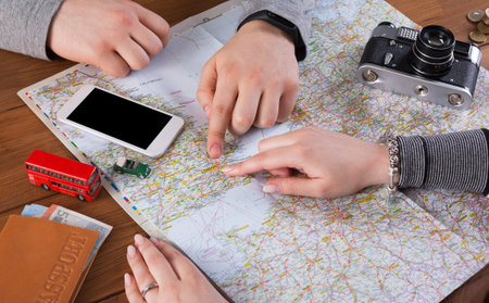 Planning a Trip With a Map and Items on a Table Including a Phone and Camera