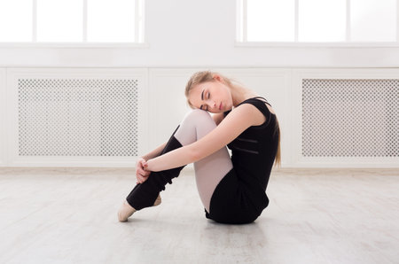 Dancer Poses on the Floor in a Studio During a Quiet Moment in the Afternoon Lightの写真素材