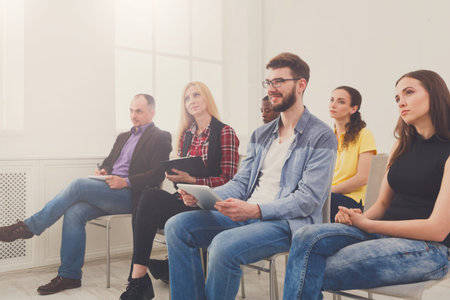 Group of People Sitting in a Room During a Meeting or Presentation in the Afternoonの写真素材