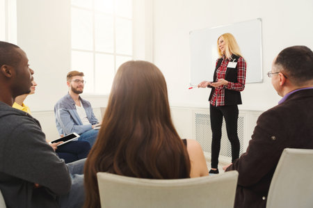 Group of People Attending a Presentation in a Bright Room With a Whiteboard