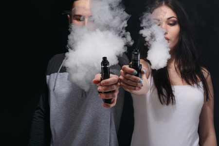 Vaping Session With Two People Creating Clouds of Vapor Indoors During Evening Hours