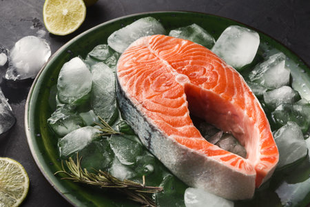 Fresh Salmon Displayed on Ice With Lime and Herbs on a Green Plate