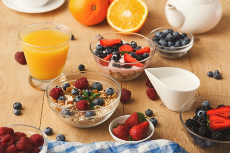 Breakfast Collection Featuring Fruits, Yogurt, and Oats on a Wooden Table With Drinks