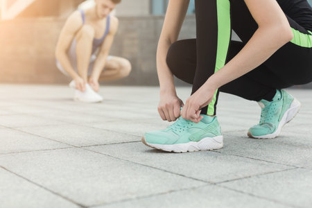 Fitness Routine Involves Two People Preparing for Exercise With Stretching and Tying Shoes