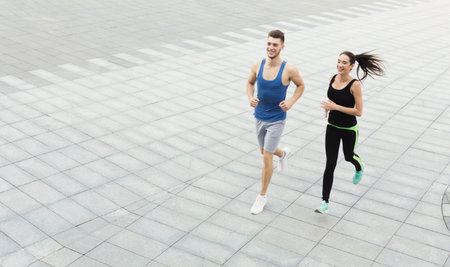 Two Individuals Are Jogging on a City Street