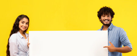 Young Adults Hold a Blank Sign Against a Bright Yellow Background in a Studio Setting