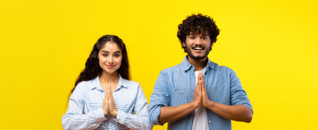 People Greeting With Hands Together Against Bright Yellow Background During Daytime