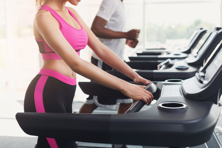 Collection of People Running on Treadmills in a Gym During Morning Hours