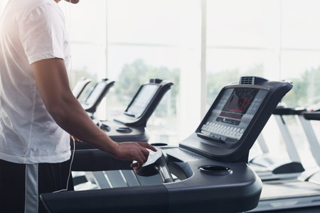 Man Using Treadmill in Gym During Workout Session in Bright Fitness Center