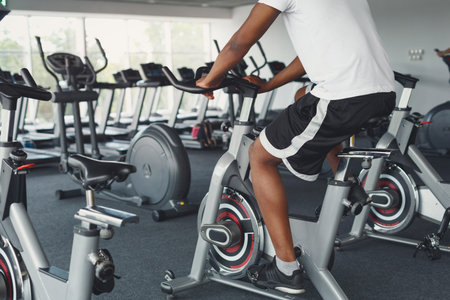 Cyclist in Fitness Center With Exercise Equipment During Workout Session in the Afternoon