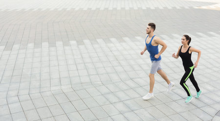 Couple Jogging Together on a Tiled Surface in a Public Space During Daytime
