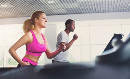 Group Exercises in Gym With Young People Running on Treadmills