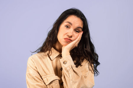 A Woman With Dark Hair is Resting Her Chin on Her Hand While Looking Directly at the Camera