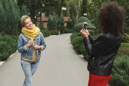 Women Have Fun Taking Pictures in a Park on a Sunny Day During Autumn Season