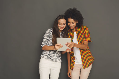 Friends Share Moments With a Tablet in a Simple Indoor Settingの写真素材
