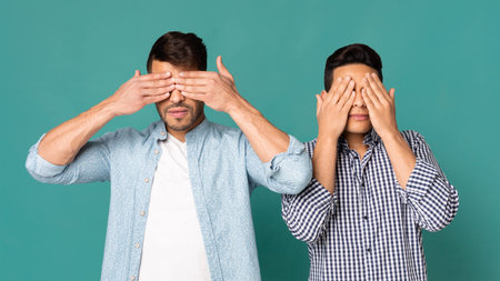Two Men Covering Their Eyes With Hands On Turquoise Background