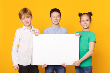 Happy children holding blank banner for advertisement