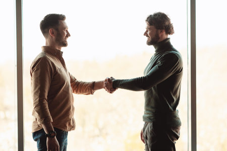Two Men Shaking Hands In Office Setting, Business Meeting Concept