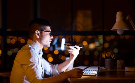Serious Entrepreneur Using Loudspeaker Talking On Cellphone In Modern Office