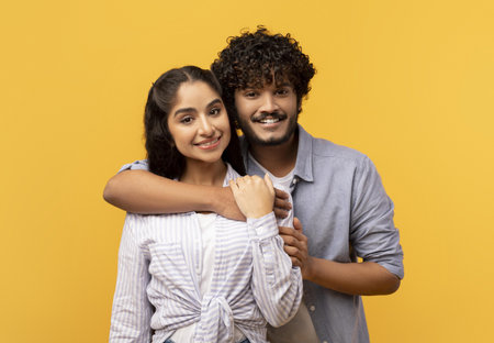 Happy Young Couple Embracing, Smiling Together With Yellow Background, Love Concept