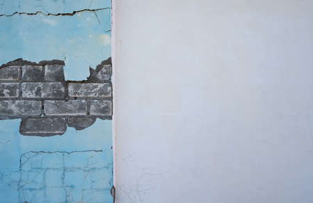 Brick wall with cracked destroyed plaster and with a concrete plastered wall an empty space texture background.の写真素材
