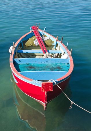 Coloured rowboat in clear sea.の写真素材