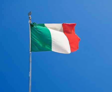 Italian flag on blue sky.の写真素材