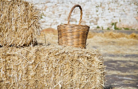Wicker basket leaning on haistacks bales.の写真素材