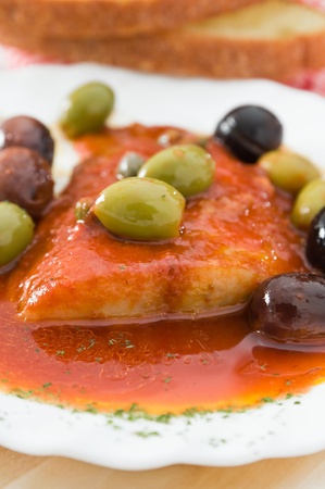 Fish with olives in tomato sauce.の写真素材
