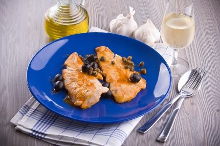 Fish fillet with black olives and capers  の写真素材
