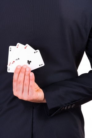 Businessman holding playing cards behind his back 