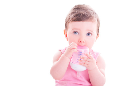 Baby girl with pink baby bottle.の写真素材