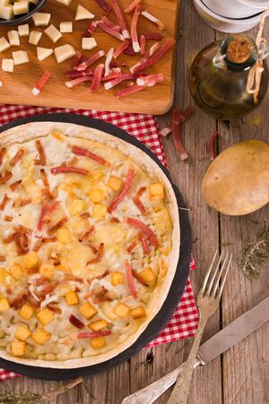 Tart with fried potato, raclette cheese and smoke flavour bacon.の写真素材