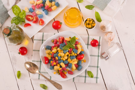 Colored gnocchi with vegetables and sweet corn.の写真素材