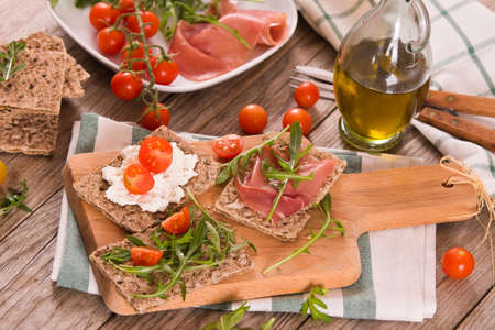 Crispy rye bread with sesame seeds, ham and cottage cheese.の写真素材