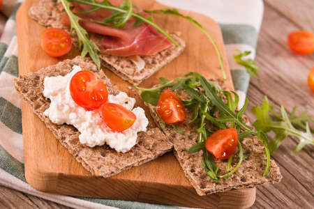 Crispy rye bread with sesame seeds, ham and cottage cheese.