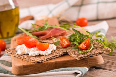 Crispy rye bread with sesame seeds, ham and cottage cheese.の写真素材