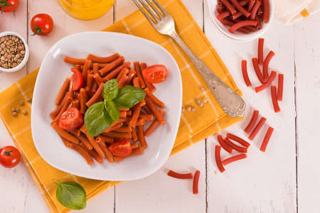 Lentil pasta with cherry tomatoes and basil.の写真素材