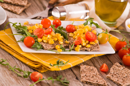 Crispy rye bread with sesame seeds, arugula and sweet corn.の写真素材