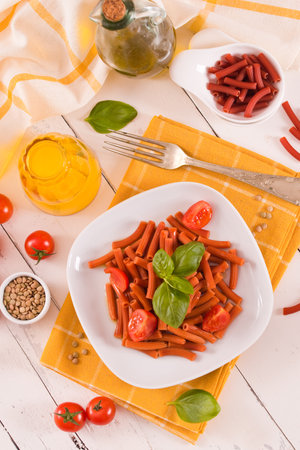 Lentil pasta with cherry tomatoes and basil.の写真素材