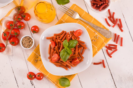 Lentil pasta with cherry tomatoes and basil.の写真素材