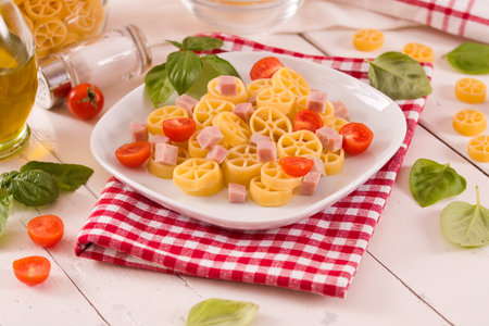 Pasta wheels with tomato and ham.の写真素材