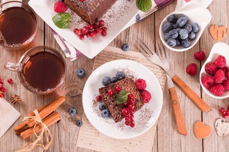 Chocolate sponge cake with fresh fruit on white dish.の写真素材
