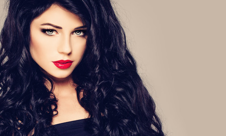 Dark Haired Woman. Brunette Girl with Curly Hair and Makeup. Fashion Portraitの写真素材