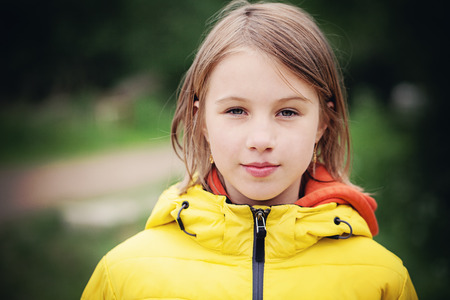 Young Girl in a Yellow Jacket Outdoorsの写真素材