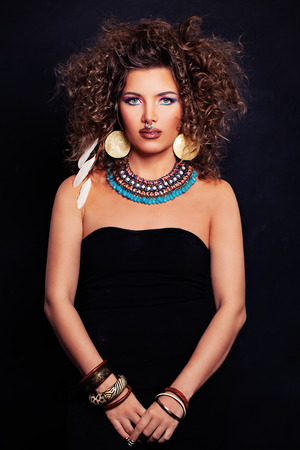 Beautiful Woman Fashion Model with Curly Hairstyle, Makeup and Accessories in the Ethnic styleの写真素材