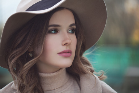 Beautiful Model Woman in Beige Hat Outdoors. Woman with Makeup, Cute Face Closeupの写真素材