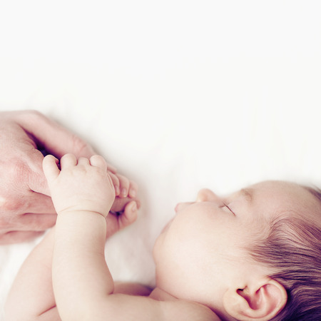 Baby and fathers hand, parental loveの写真素材