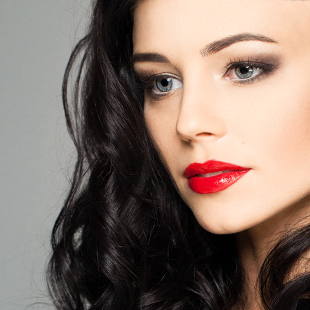 Cute female face with stage makeup smokey eyes and red lipsの写真素材