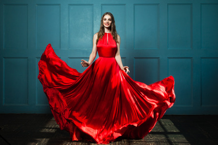 Glamorous Woman in Fashionable Red Dress. Beautiful Fashion Model, Full Portraitの写真素材